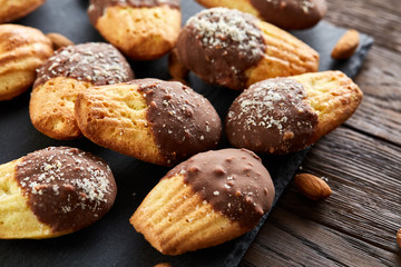 Freshly baked almond cookies on stone board over wooden background, top view, selective focus.