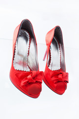red female shoes with a bow on a white background 