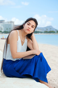 Biracial teen sitting on Hawaiian beach, thinking. Waikiki, Honolulu