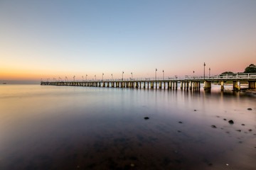Fototapeta na wymiar Amazing sunrise on the pier at the seaside. Gdynia Orlowo, Poland