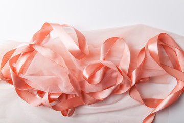 Shiny pink satin ribbon with transparent fabric on white background