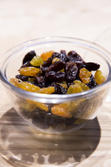 Raisins in a glass bowl  on wooden table.