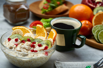 Breakfast still life with oatmeal porridge, fruits and coffee cup, top view, selective focus, shallow depth of field.
