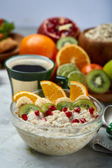 Breakfast still life with oatmeal porridge, fruits and coffee cup, top view, selective focus, shallow depth of field.