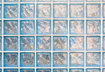 Blue glass block wall reflecting sunlight. Texture background