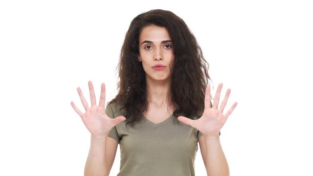 Portrait of caucasian determined woman expressing perplexity and confusion with showing stop gestures and saying no, over white background. Concept of emotions