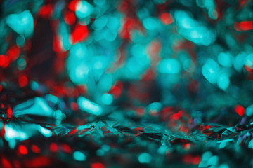 Modern abstract blurred foil background lit by teal and red lamp