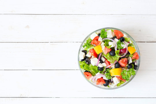 Fresh Greek Salad In A Bowl On Wooden Table, Top View