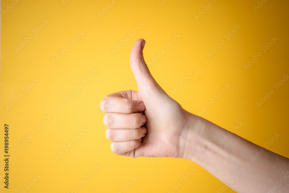 Wall mural emale hand showing thumbs up gesture