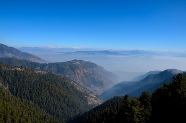 Murree / Nathia Gali, Pakistan - January 12, 2018: A distant view of Himalayan mountain range between the Pakistani towns of Murree and Nathia Gali. Both towns are popular tourist spots. 