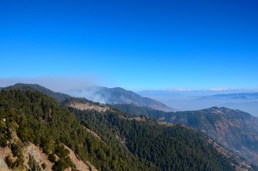 Murree / Nathia Gali, Pakistan - January 12, 2018: A distant view of Himalayan mountain range between the Pakistani towns of Murree and Nathia Gali. Both towns are popular tourist spots. 