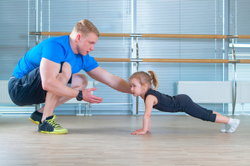 Obraz premium Group of children doing kids gymnastics in gym with teacher. Happy sporty children in gym. bar exercise. plank.
