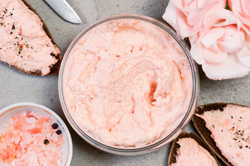 Salmon pate in the glass jar and on pieces of rye bread