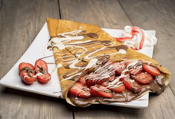 Crepes with Strawberry, chocolate syrup, and cream