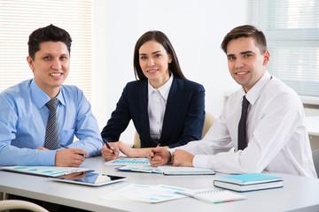 Obraz premium Young business people smiling looking at camera