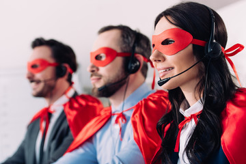 super businesspeople in masks and headsets supporting customers in call center