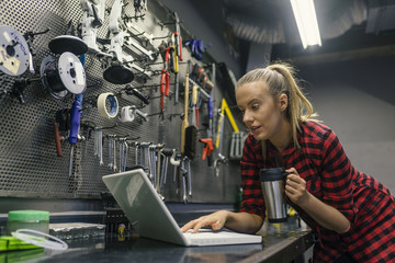 Young female mechanic with laptop