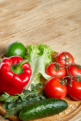 Artistic still life of assorted fresh vegetables and herbs on rustic wooden background, top view, selective focus.