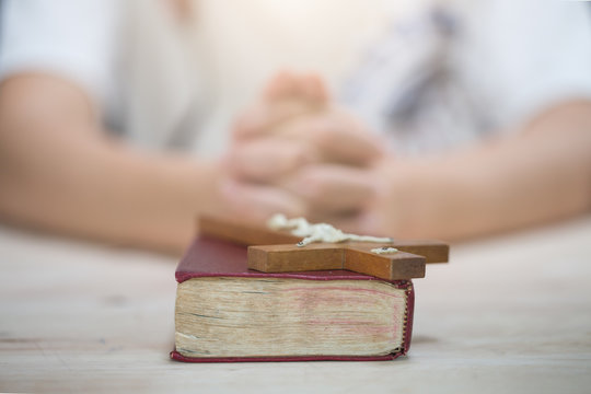 woman hands on bible. she is reading and praying over bible over wooden table