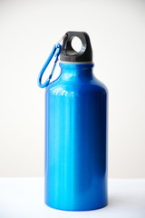 Blue metal flask, on a white background. Close up, isolated. Sports, active vacation