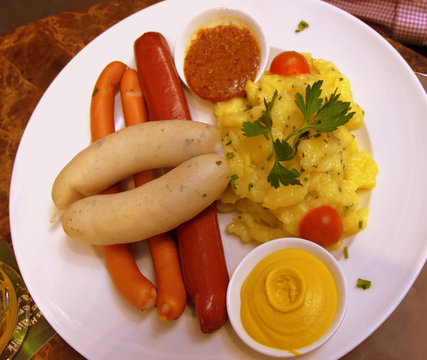 Wurstplatte mit Wei&szlig;w&uuml;rsten, gekochter Rindswurst, Frankfurter W&uuml;rstchen und Kartoffelsalat