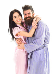 Couple in love hugging in pajama, bathrobe. Couple, family on smiling faces happy in morning. Relations goals concept. Couple cuddling, girl kissing macho, isolated on white background.