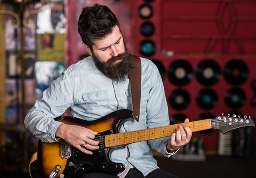 Musician with beard play electric guitar musical instrument.