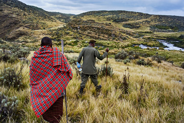 Traditional Masai and Ranger hiking in crater moutain
