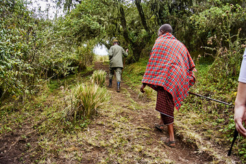 Traditional Masai and Ranger hiking in crater moutain