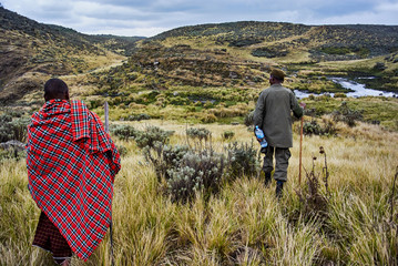 Traditional Masai and Ranger hiking in crater moutain
