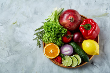 Still life of fresh organic vegetables on wooden plate over white background, selective focus, close-up