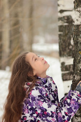 Fototapeta premium young girl with long hair in the winter forest near the birch