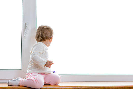 the child sits and looks out of the window