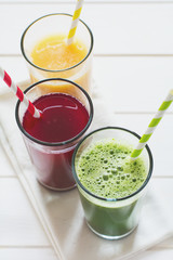 Detox drinks in glass: fresh smoothies from vegetables: beet, pumpkin and spinach on white background