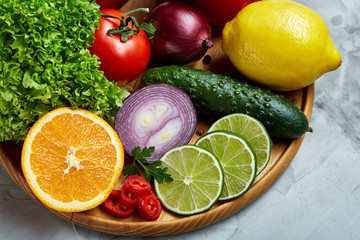 Still life of fresh organic vegetables on wooden plate over white background, selective focus, close-up