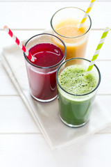 Detox drinks in glass: fresh smoothies from vegetables: beet, pumpkin and spinach on white background