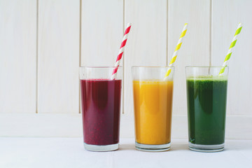 Detox drinks in glass: fresh smoothies from vegetables: beet, pumpkin and spinach on white background