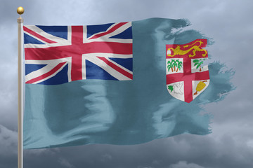 Fiji Flag with torn edges in front of a stormy sky