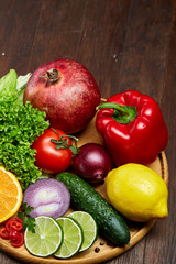 Still life of fresh organic vegetables on wooden plate over wooden background, selective focus, close-up