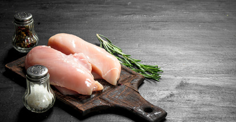 Raw chicken fillet with rosemary and spices. - obrazy, fototapety, plakaty