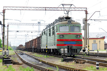 Fototapeta na wymiar Electric locomotive of green color pulls freight cars