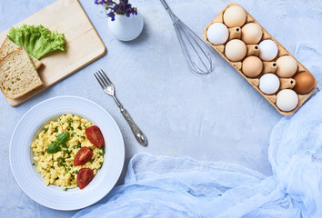 Scrambled eggs in plate on rustic background