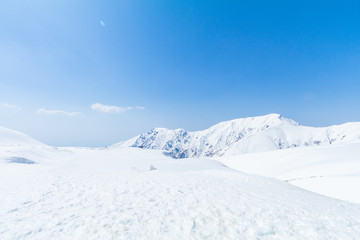 Tateyama Kurobe Alpine Route, the snow mountains wall with blue sky background in Toyama Prefecture, Japan.