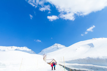 TOYAMA , JAPAN - April 30, 2017:People are walking at Tateyama Kurobe Alpine Route , the road between the snow mountains wall  with blue sky background in Toyama Prefecture, Japan.