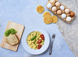Scrambled eggs in plate on rustic background