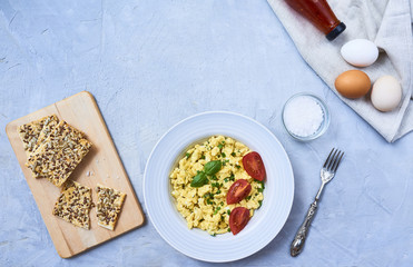 Scrambled eggs in plate on rustic background