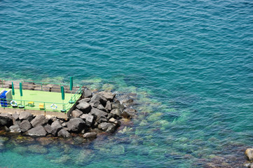 Blue transparent sea water around a pontoon in Sorento, above view