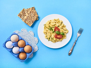 Scrambled eggs in plate on rustic background