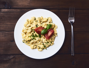 Scrambled eggs in plate on rustic background