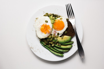 sandwich with fresh vegetables, avocado, hard-boiled eggs and pumpkin seeds with olive oil and bread. healthy diet or vegetarian food on a white background. salad with yolks on toast. top view